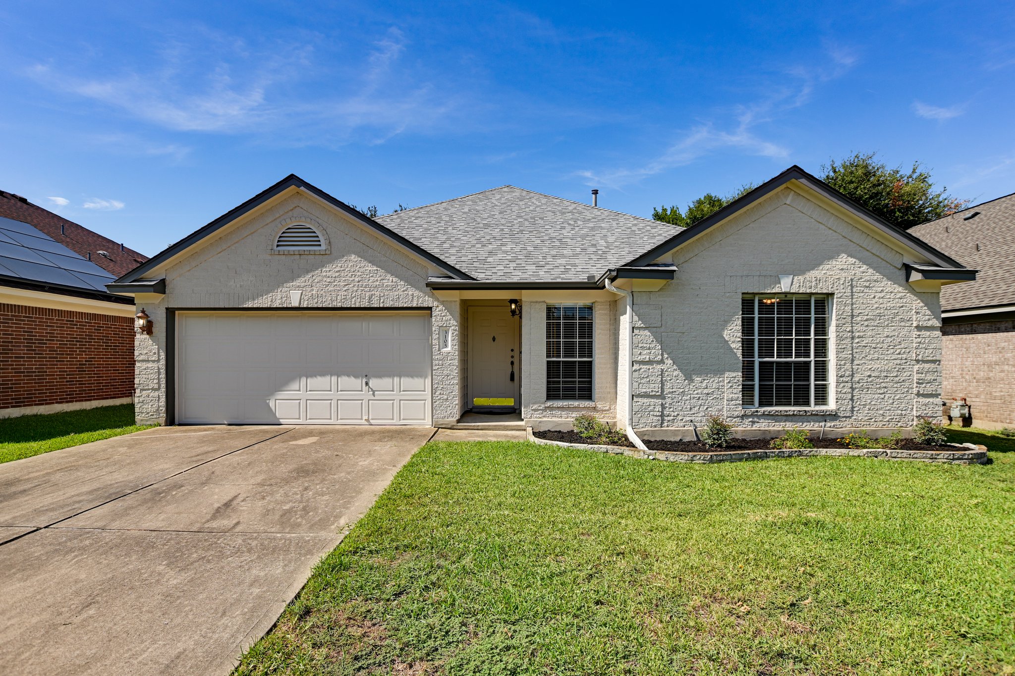 a front view of a house with a garden and yard