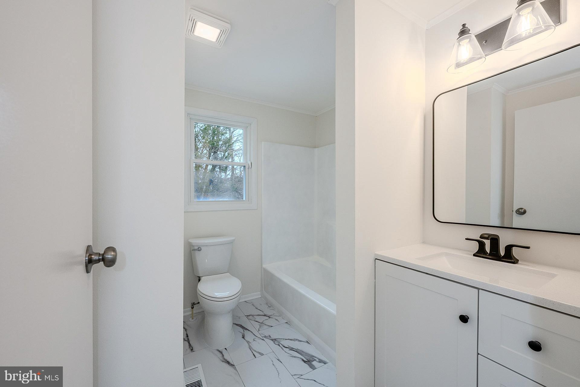 8414 Belding Court Brandywine, MD 20613 - Photo 24 of 37 a bathroom with a granite countertop sink toilet a large mirror a vanity and shower