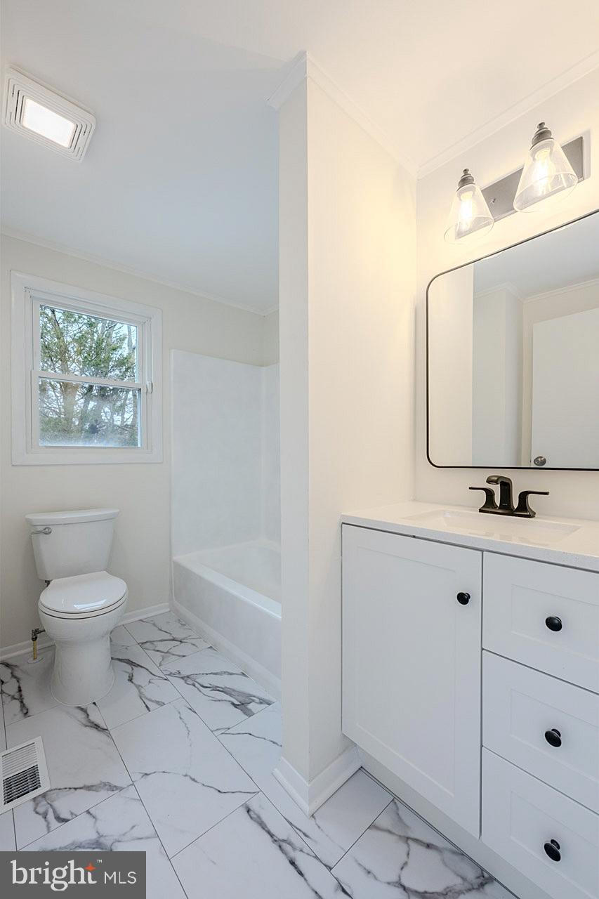 8414 Belding Court Brandywine, MD 20613 - Photo 25 of 37 a bathroom with a toilet sink and mirror