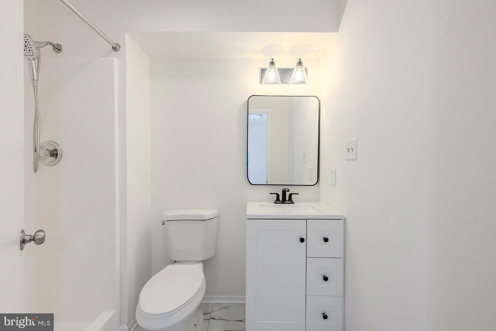 8414 Belding Court Brandywine, MD 20613 - Photo 28 of 37 a bathroom with a toilet sink vanity and mirror