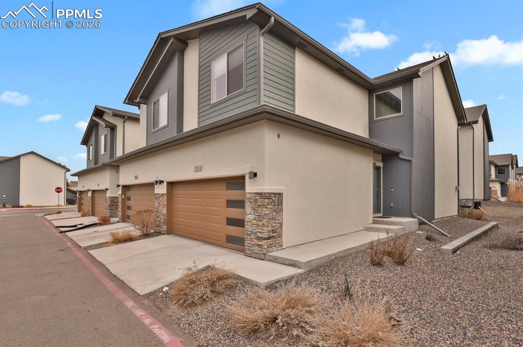 5353 Freeboot Point Colorado Springs, CO 80922 - Photo 1 of 28 a front view of a house with a yard and garage