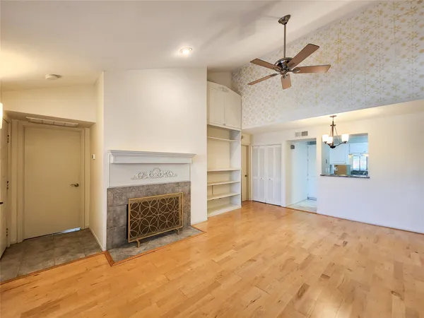 a view of empty room with a fireplace and fan