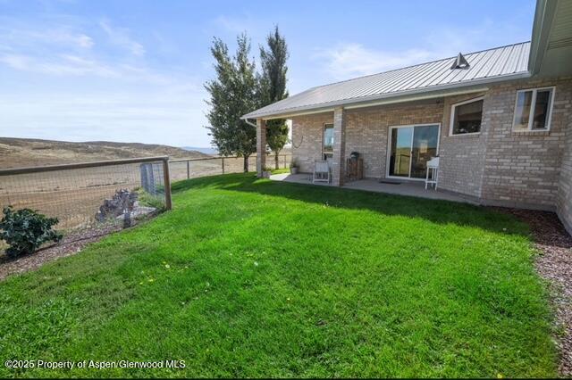 1040 Pronghorn Road Craig, CO 81625 - Photo 14 of 70 a view of a yard in front of a house with large windows