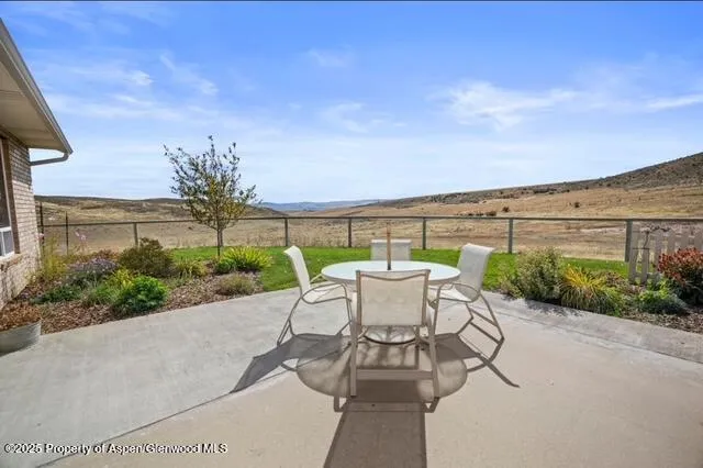 a view of a yard in front of a house with large windows
