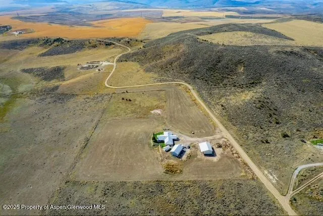 a kitchen with stainless steel appliances a refrigerator a stove a sink dishwasher and a dining table with wooden cabinet