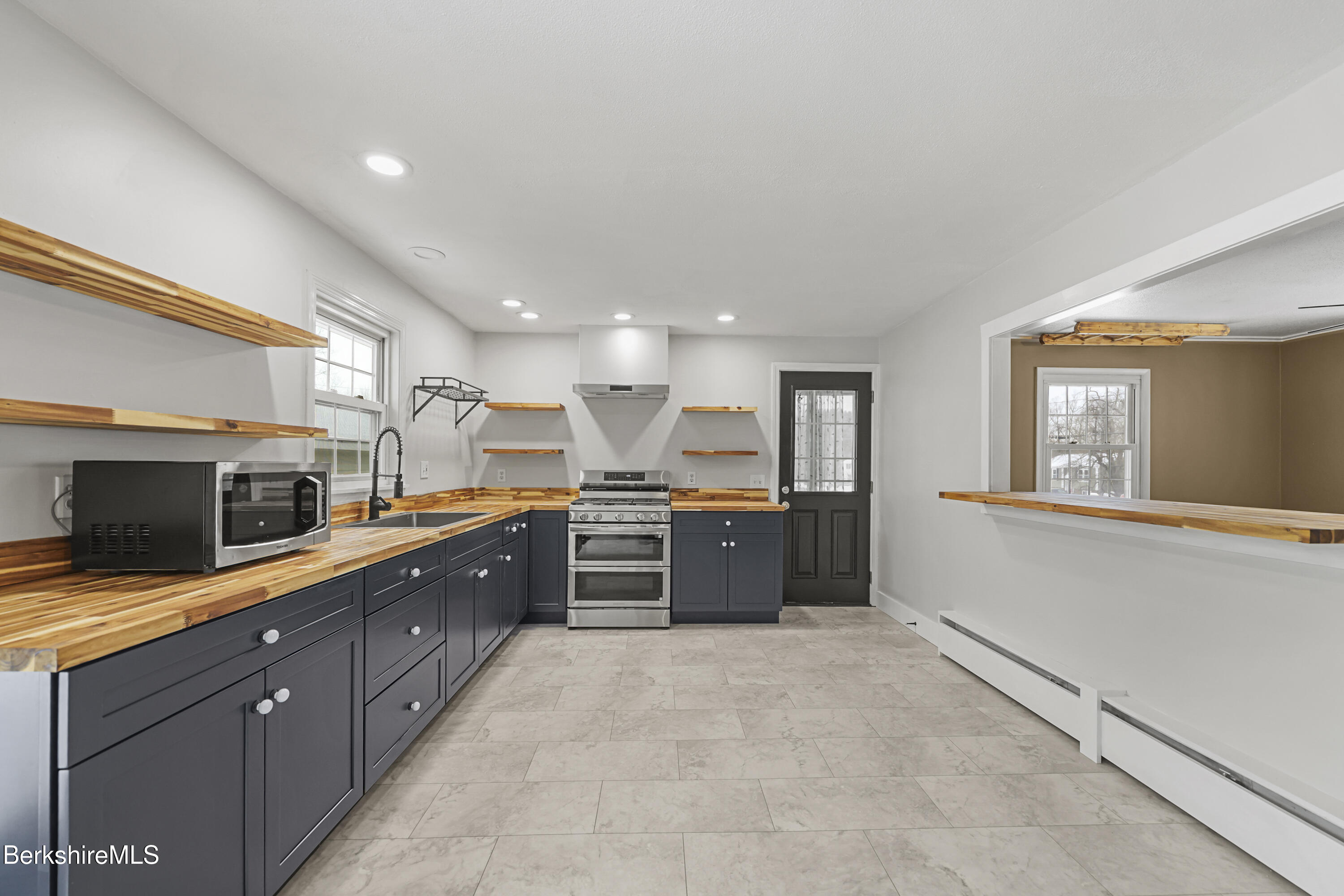 290 East Center Street Lee, MA 01238 - Photo 13 of 47 a large kitchen with kitchen island granite countertop a large counter top stainless steel appliances and cabinets