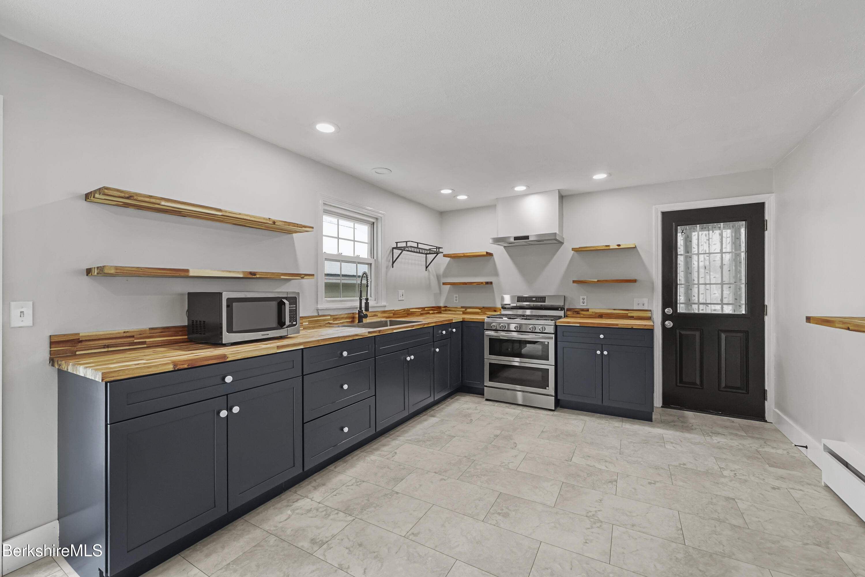 290 East Center Street Lee, MA 01238 - Photo 16 of 47 a large kitchen with a large counter top and stainless steel appliances