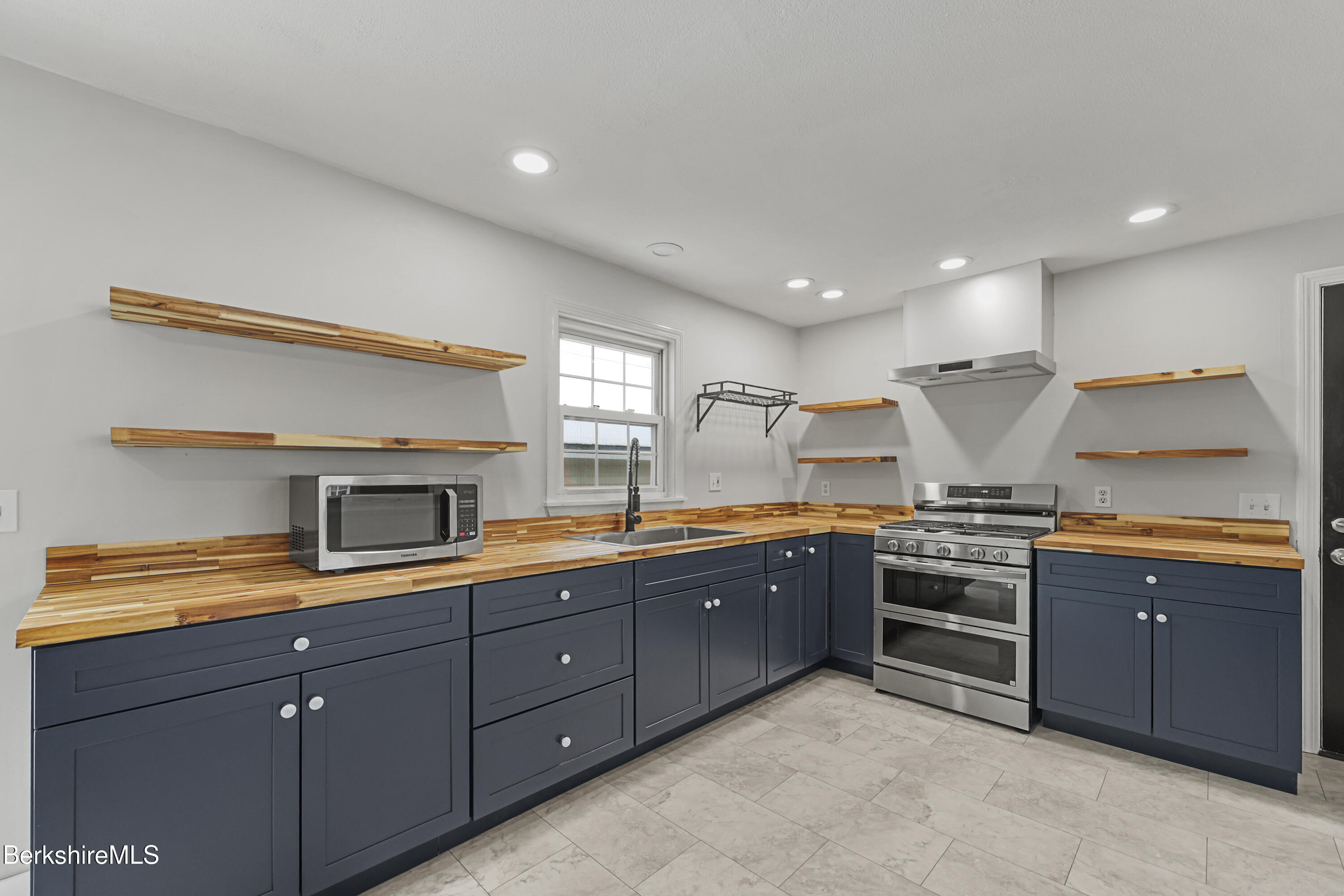 290 East Center Street Lee, MA 01238 - Photo 17 of 47 a large kitchen with stainless steel appliances granite countertop a stove and a sink