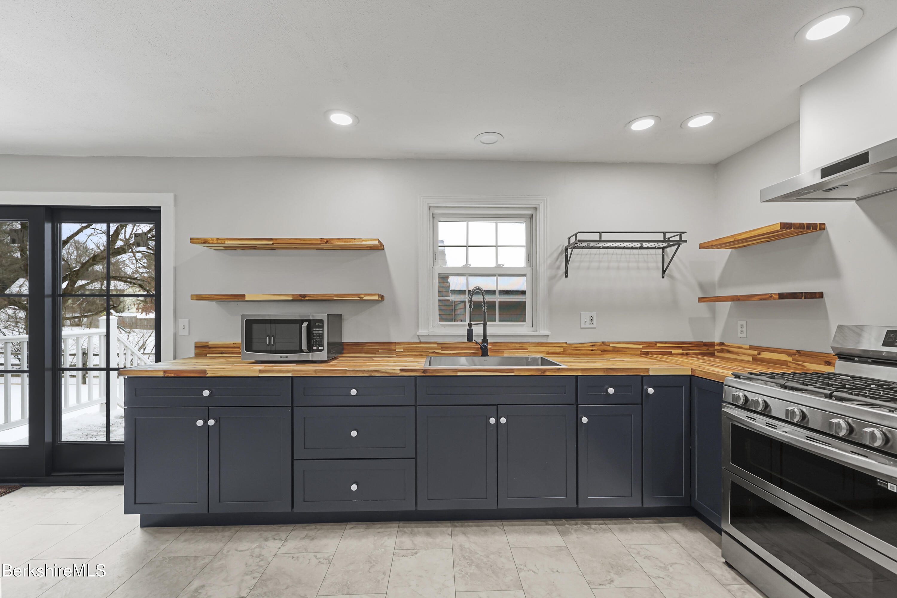 290 East Center Street Lee, MA 01238 - Photo 19 of 47 a kitchen with stainless steel appliances granite countertop a stove a sink and a refrigerator