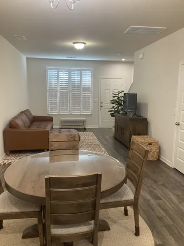 a kitchen with a dining table chairs and refrigerator