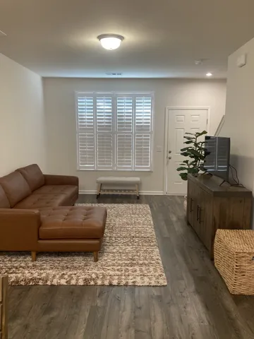 a living room with furniture and floor to ceiling window