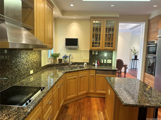 a kitchen with stainless steel appliances granite countertop a sink stove and cabinets
