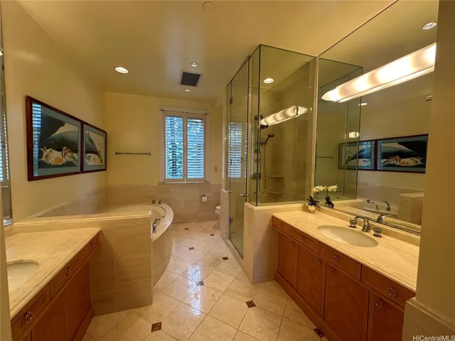a bathroom with a double vanity sink mirror and bathtub