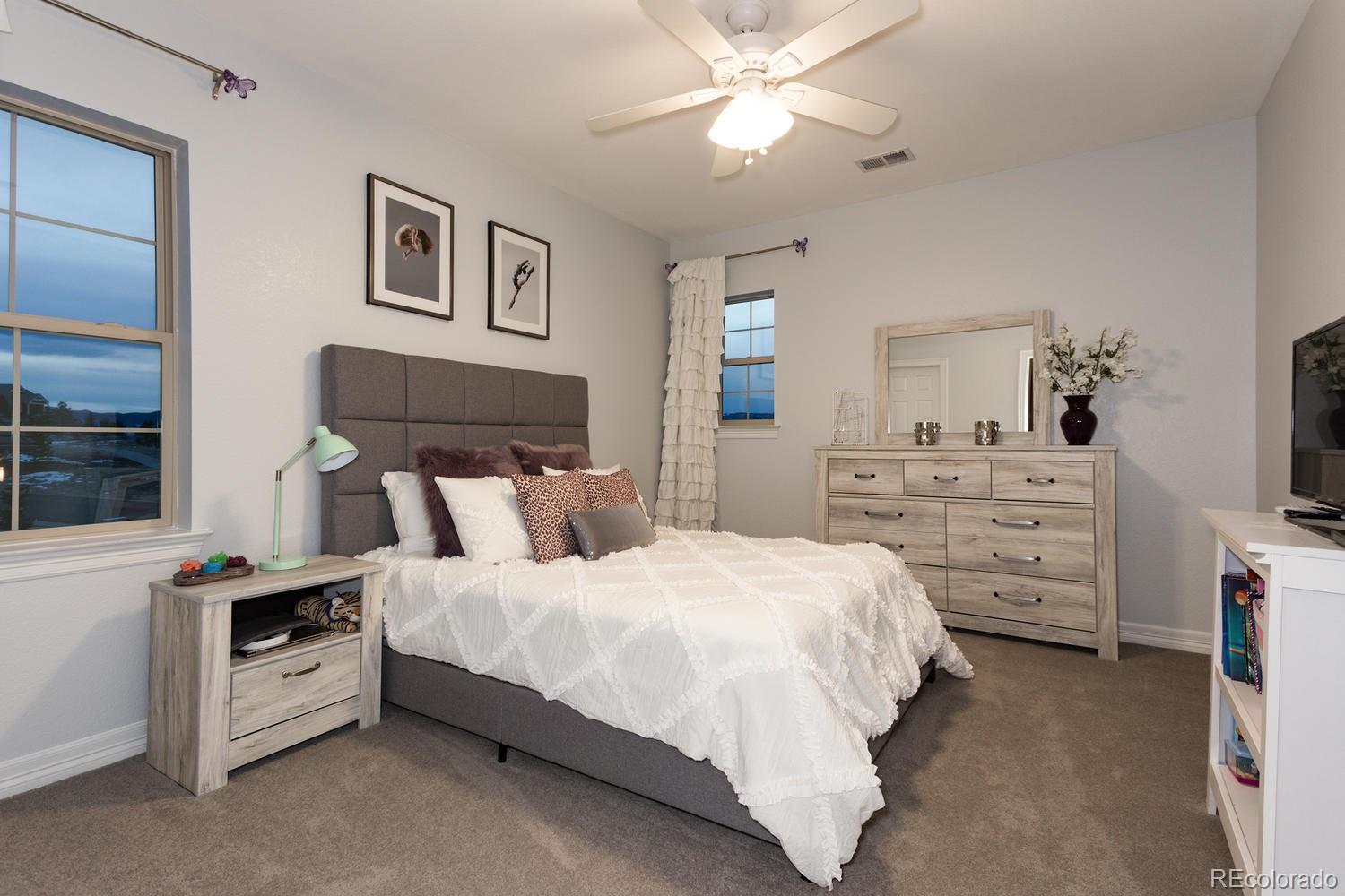 10808 Sundial Rim Road Highlands Ranch, CO 80126 - Photo 15 of 26 a bedroom with a bed and a chandelier