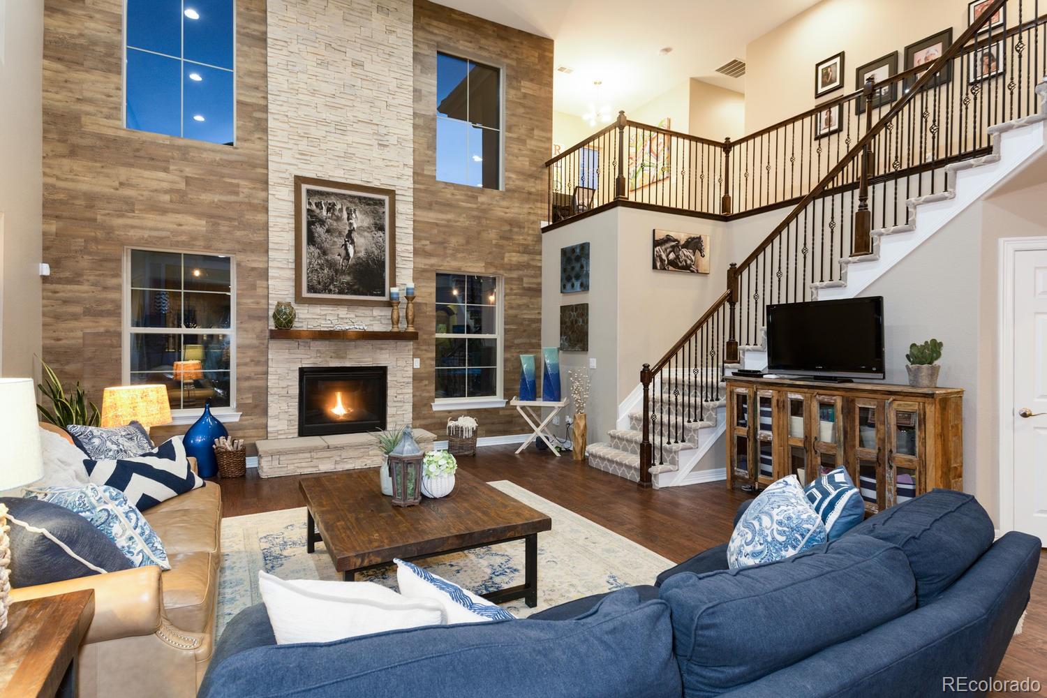 10808 Sundial Rim Road Highlands Ranch, CO 80126 - Photo 18 of 26 a living room with furniture fireplace and a flat screen tv