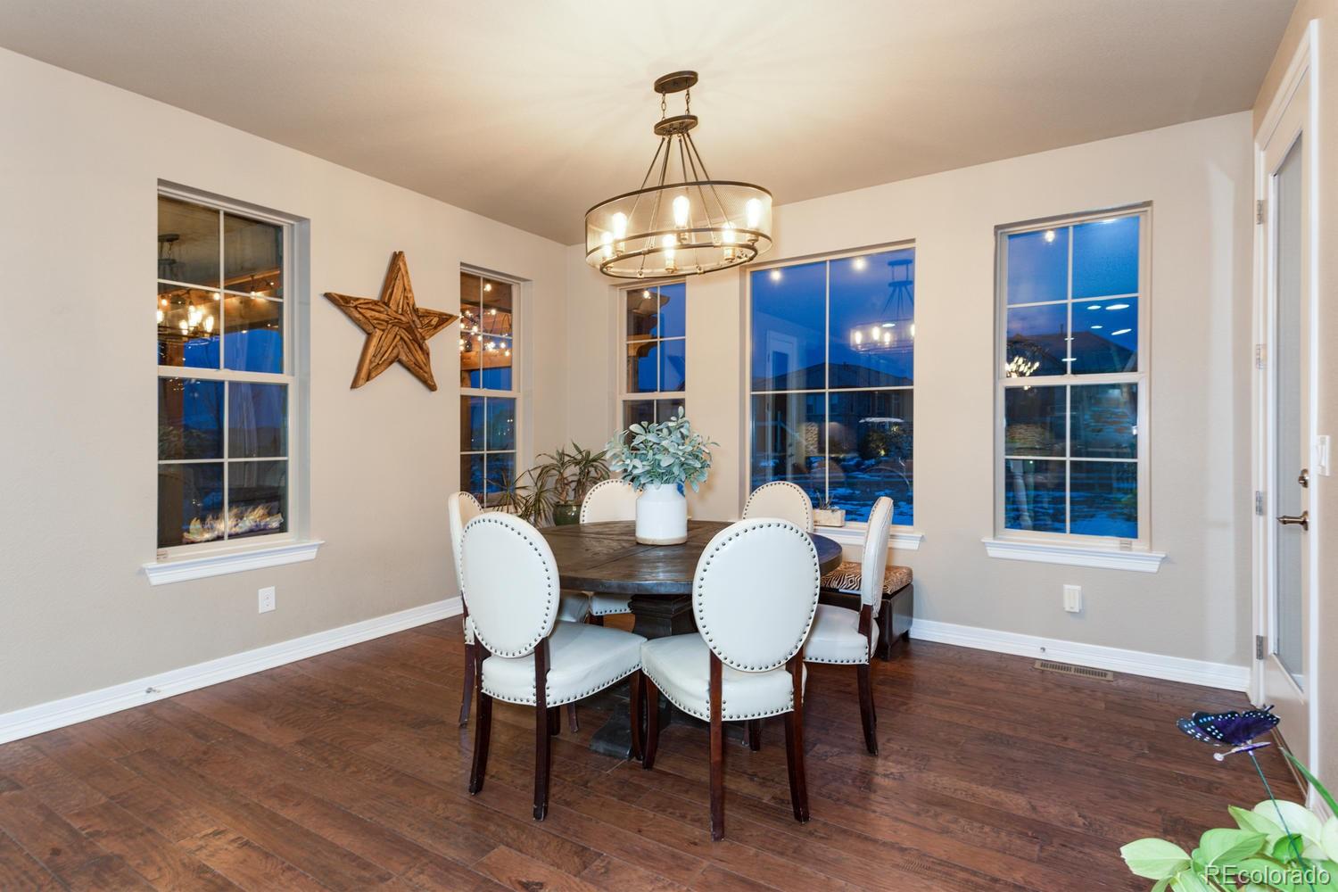 10808 Sundial Rim Road Highlands Ranch, CO 80126 - Photo 8 of 26 a view of a dining room with furniture wooden floor and chandelier