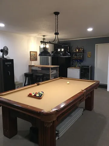 a room with pool table and wall paintings