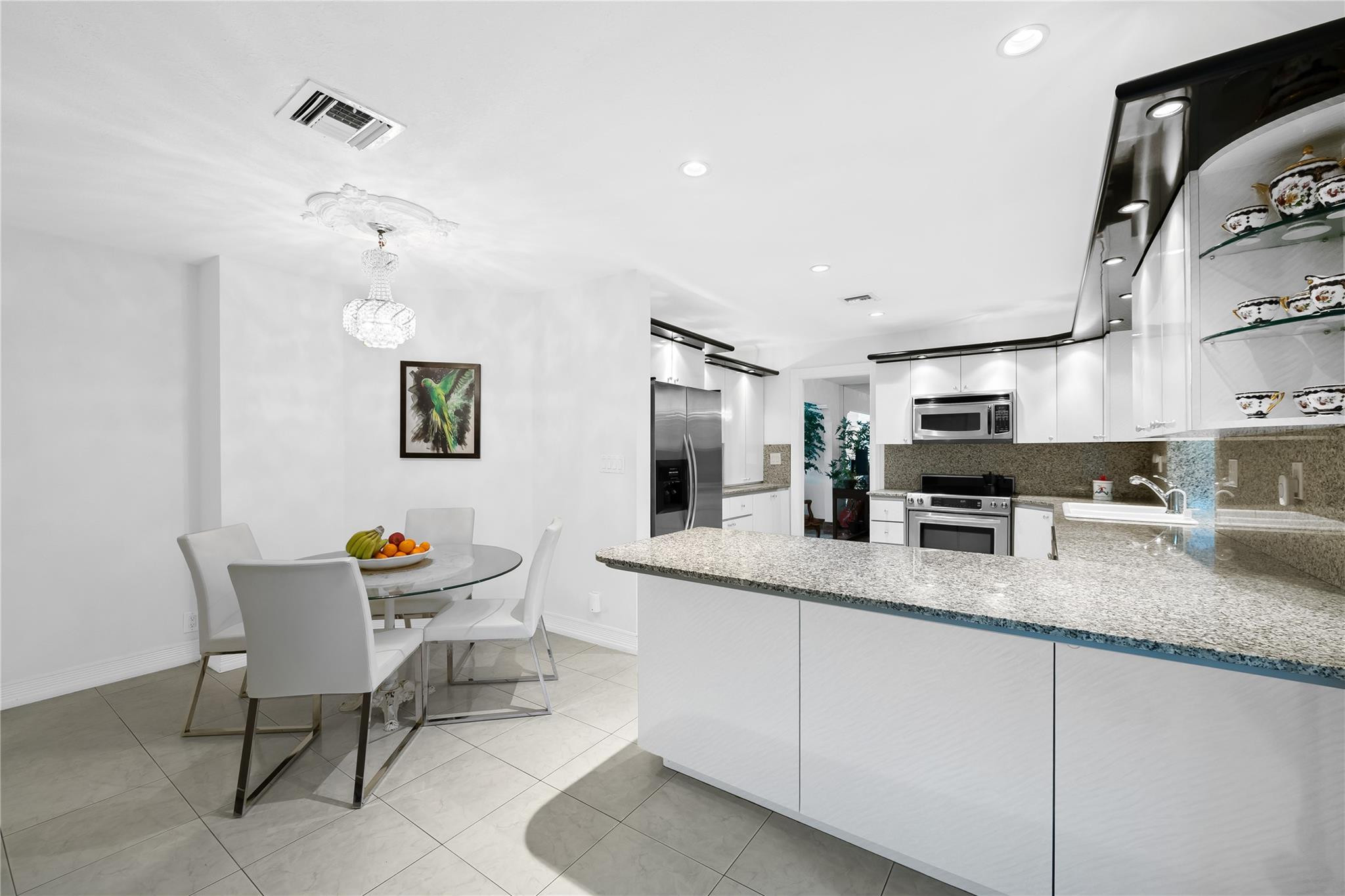 3301 Northeast 27th Avenue Lighthouse Point, FL 33064 - Photo 21 of 41 a kitchen with granite countertop stainless steel appliances a sink and a refrigerator