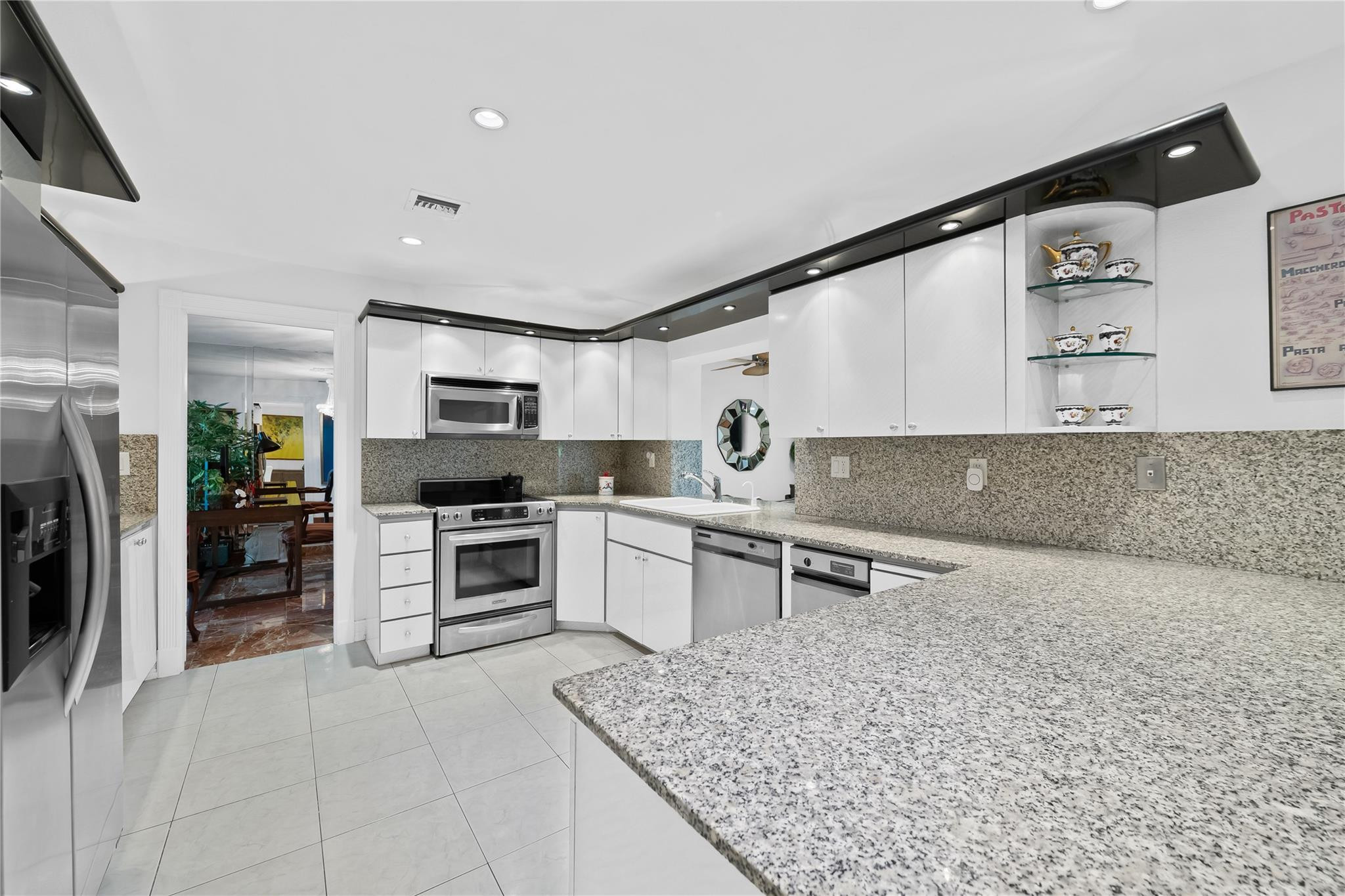 3301 Northeast 27th Avenue Lighthouse Point, FL 33064 - Photo 22 of 41 a kitchen with stainless steel appliances granite countertop a refrigerator and a sink