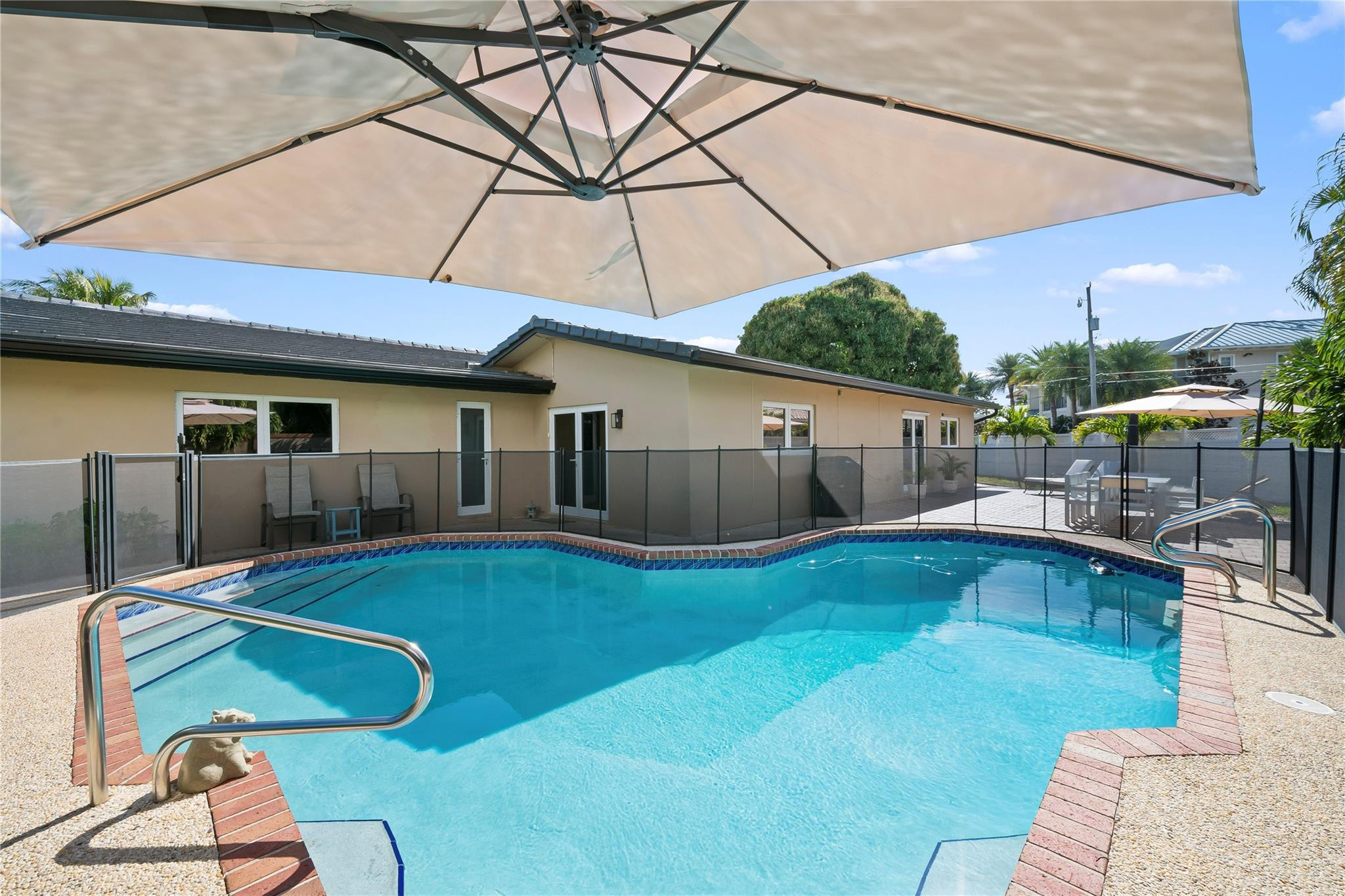 3301 Northeast 27th Avenue Lighthouse Point, FL 33064 - Photo 32 of 41 a view of a backyard with table and chairs under an umbrella