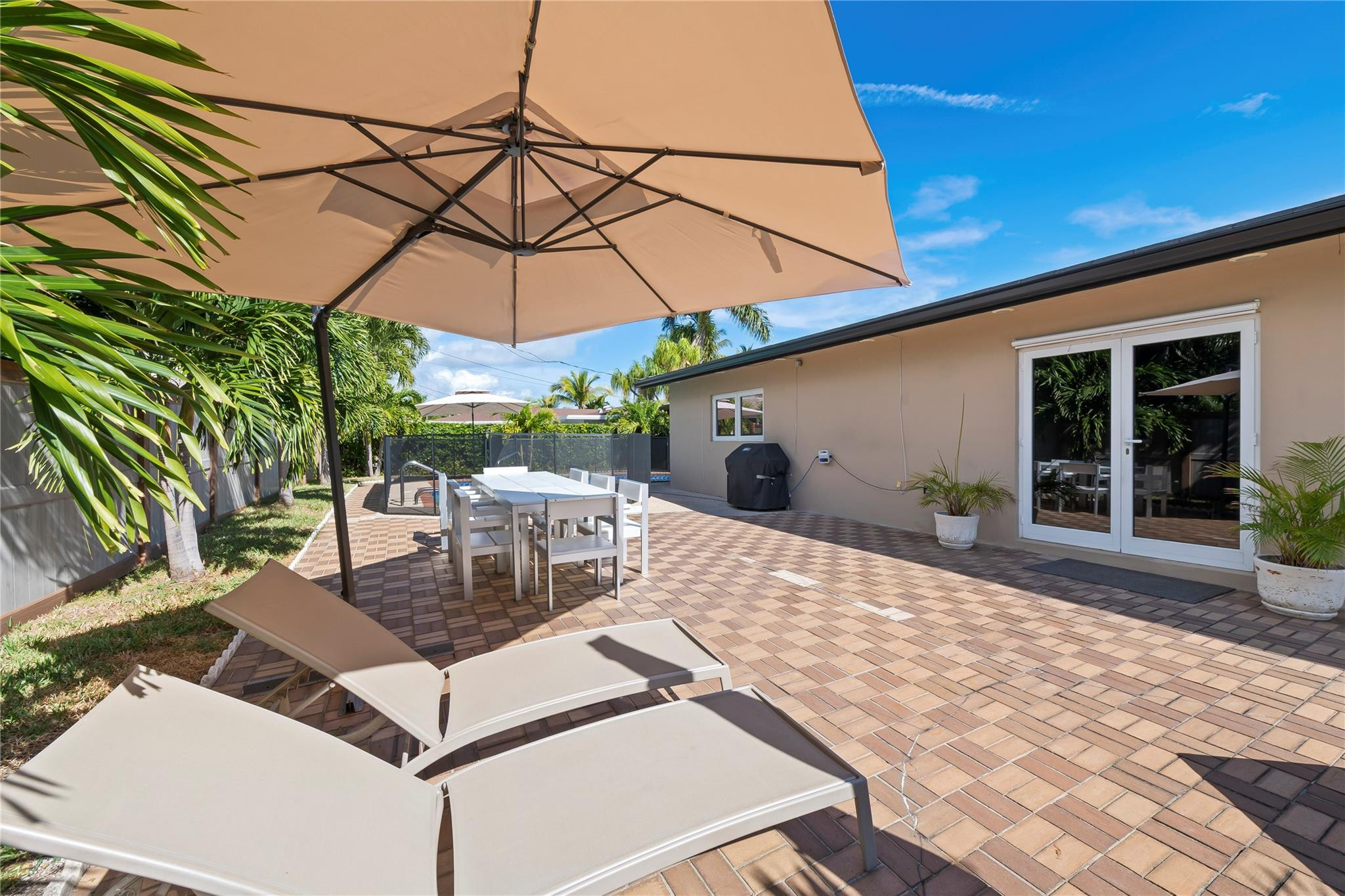 3301 Northeast 27th Avenue Lighthouse Point, FL 33064 - Photo 35 of 41 a view of a patio with a table and chairs under an umbrella
