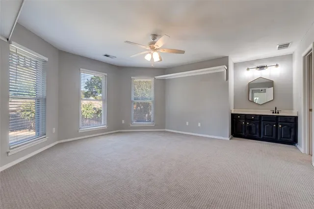 a view of an empty room with a window and a kitchen
