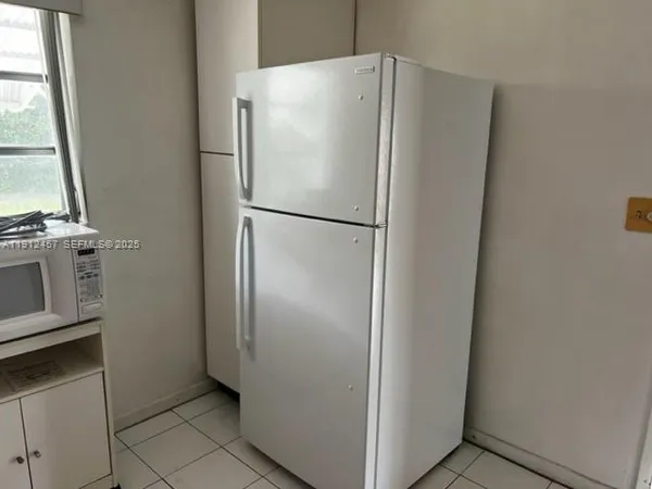 a white refrigerator freezer and a stove sitting inside of a kitchen