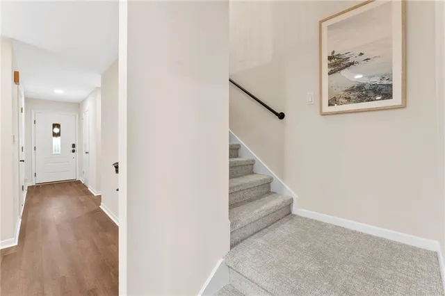 an entryway with wooden floor and stairs