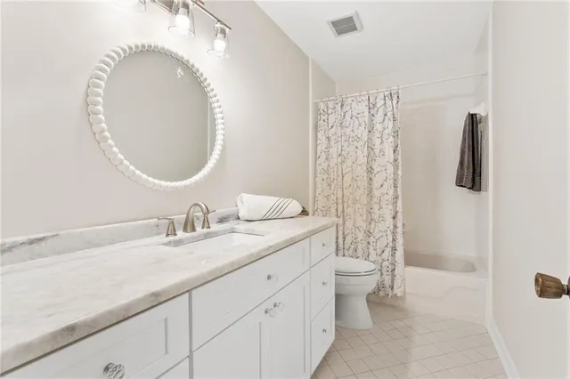 a bathroom with a granite countertop sink a toilet and a mirror
