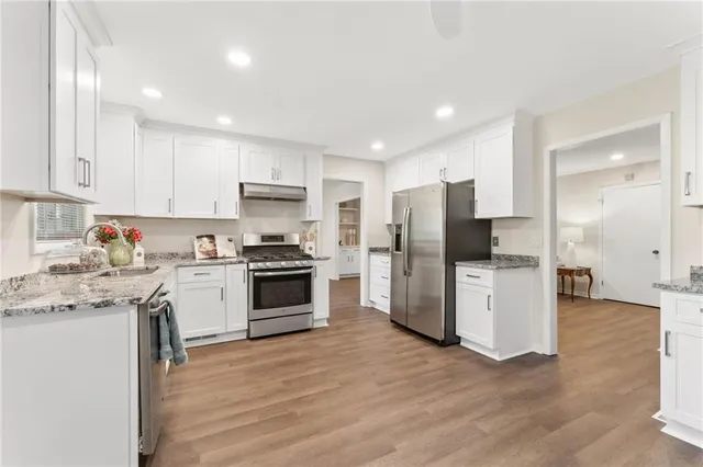 a kitchen with a refrigerator a stove top oven a sink and cabinets