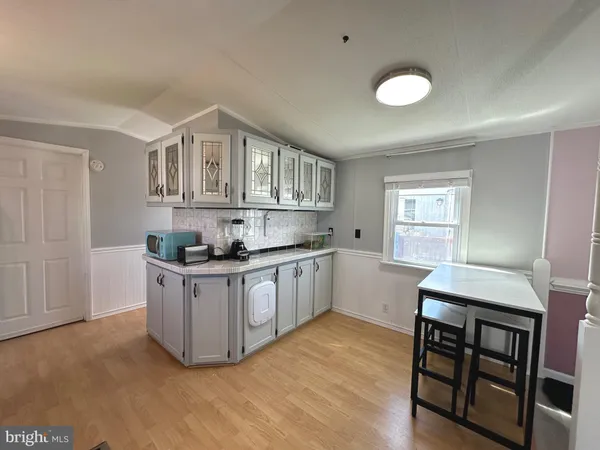 a kitchen with stainless steel appliances granite countertop a sink cabinets and wooden floor