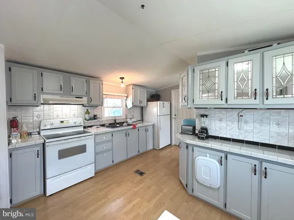 a kitchen with granite countertop white cabinets and white appliances