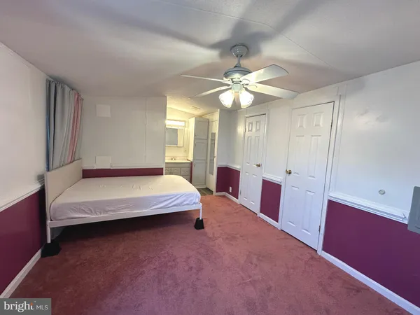 a spacious bedroom with a bed and a chandelier