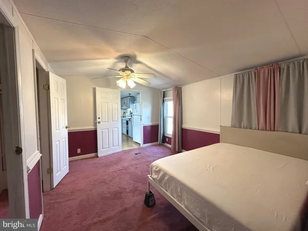 a spacious bedroom with a large bed and a chandelier