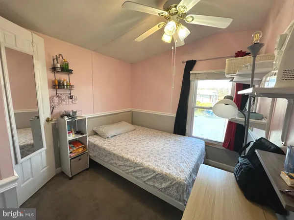 a bedroom with a bed and a flat tv screen on dresser