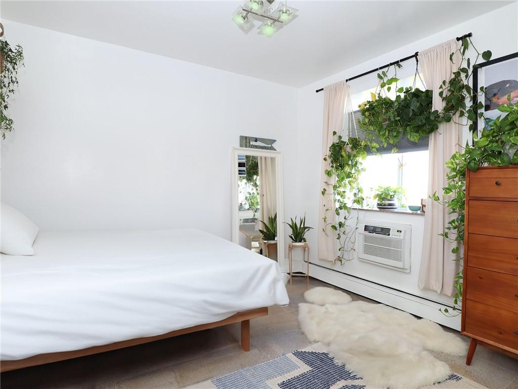 643 Morgan Avenue Brooklyn, NY 11222 - Photo 41 of 50 a bedroom with a bed table flowerpot and window
