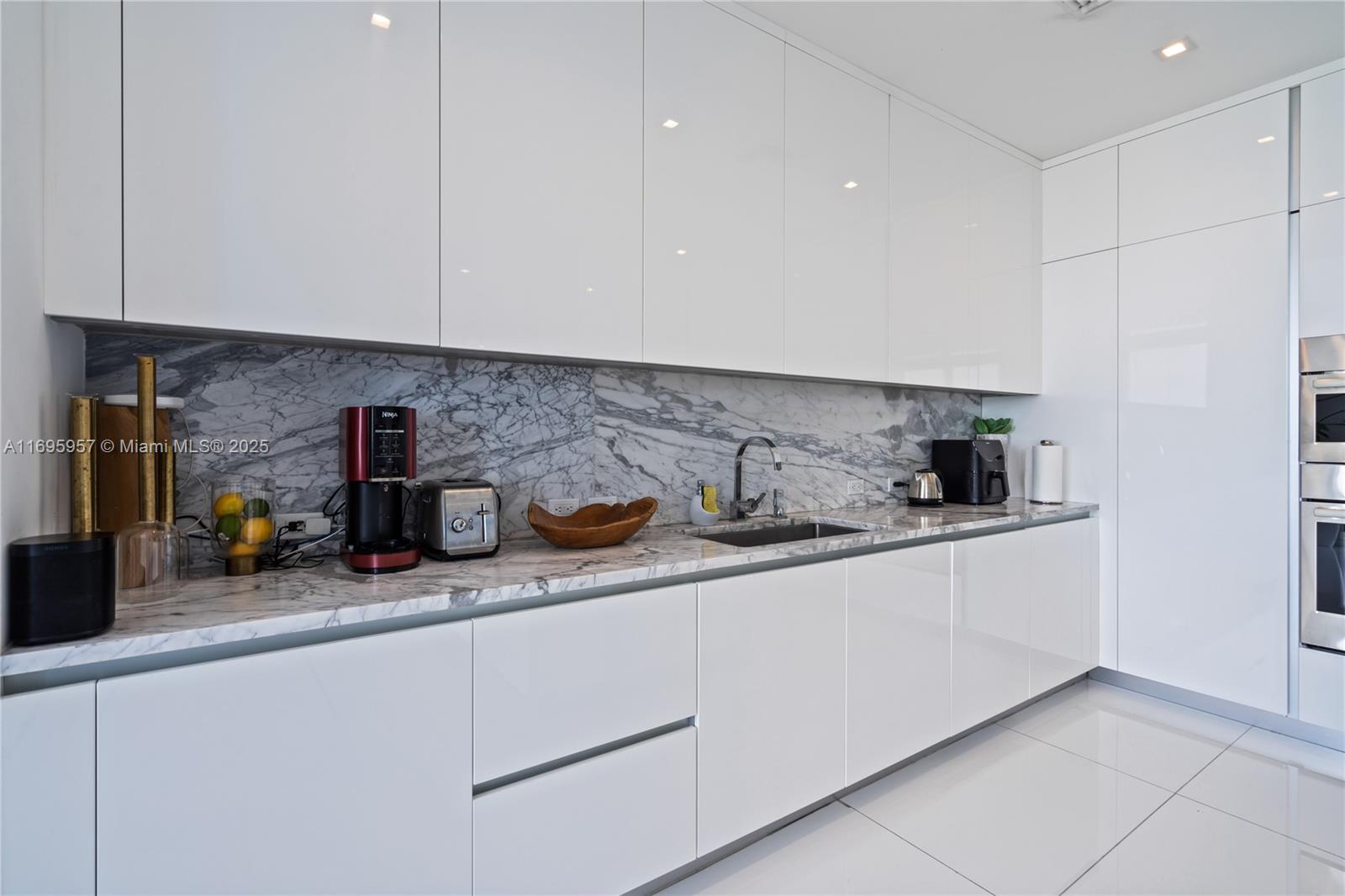 88 Southwest 7th Street, Unit 4203 Miami, FL 33130 - Photo 68 of 96 a kitchen with a sink and white cabinets