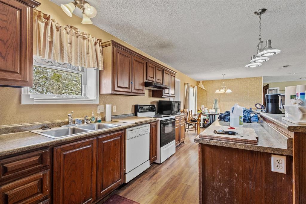 1841 County Road Honey Grove, TX 75446 - Photo 19 of 32 a kitchen with kitchen island granite countertop a sink stove and cabinets
