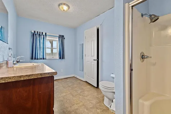 a bathroom with a granite countertop sink toilet and shower