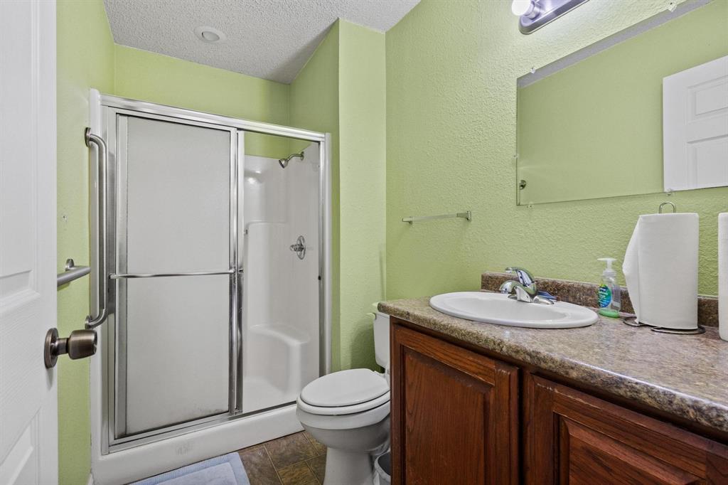 1841 County Road Honey Grove, TX 75446 - Photo 25 of 32 a bathroom with a granite countertop sink toilet and shower