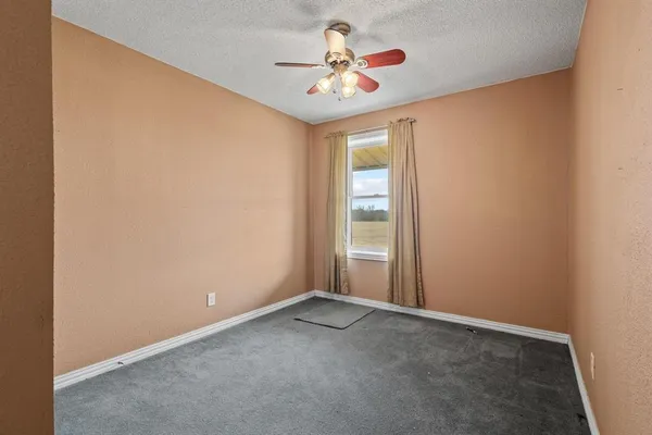 an empty room with a chandelier fan