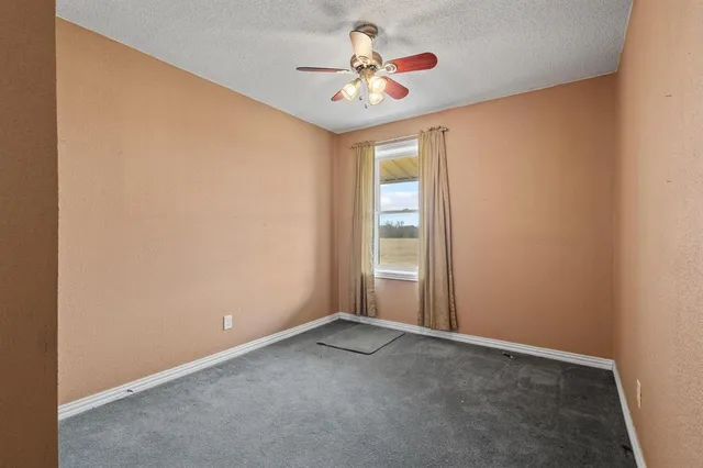 an empty room with a chandelier fan