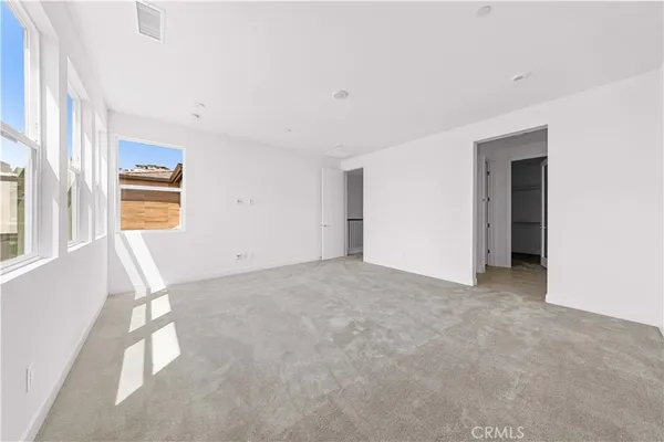 an empty room with a fireplace and windows