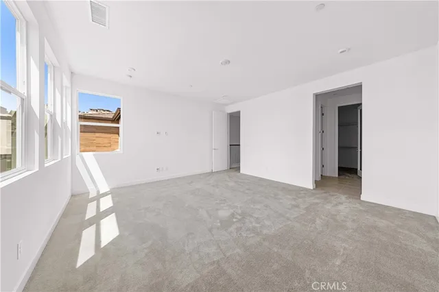 an empty room with a fireplace and windows