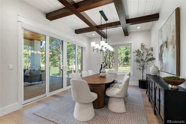 a dining room with furniture a chandelier and glass door