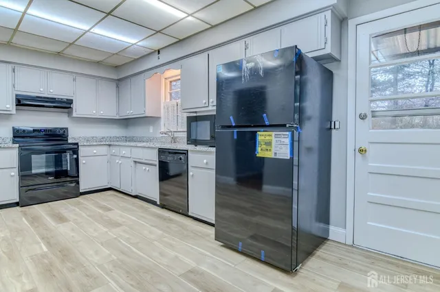 a kitchen with stainless steel appliances granite countertop a refrigerator and a stove top oven