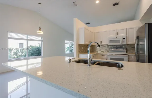 a kitchen with stainless steel appliances a sink and a large window