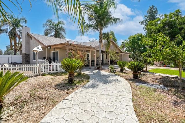 a view of a house with a swimming pool and sitting area