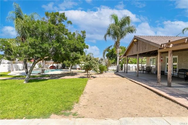 a swimming pool with outdoor seating and yard