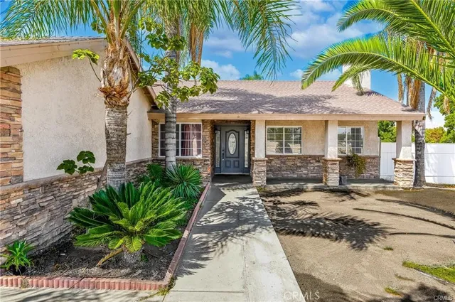 a view of a house with a small yard plants and palm trees